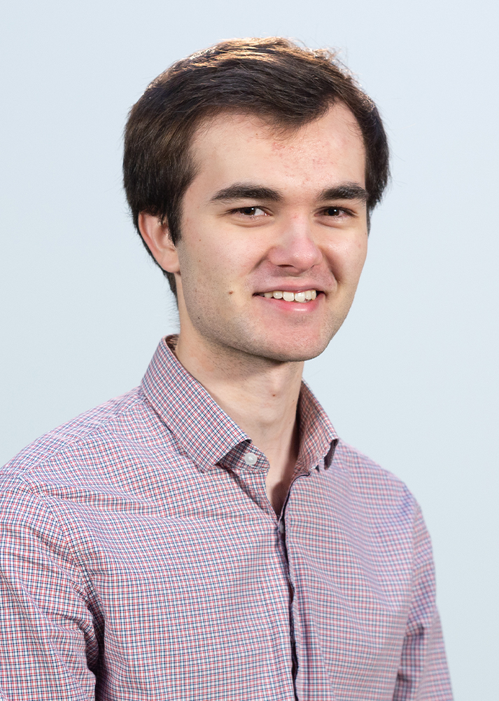 Daniel Ball smiling at the camera on a white background