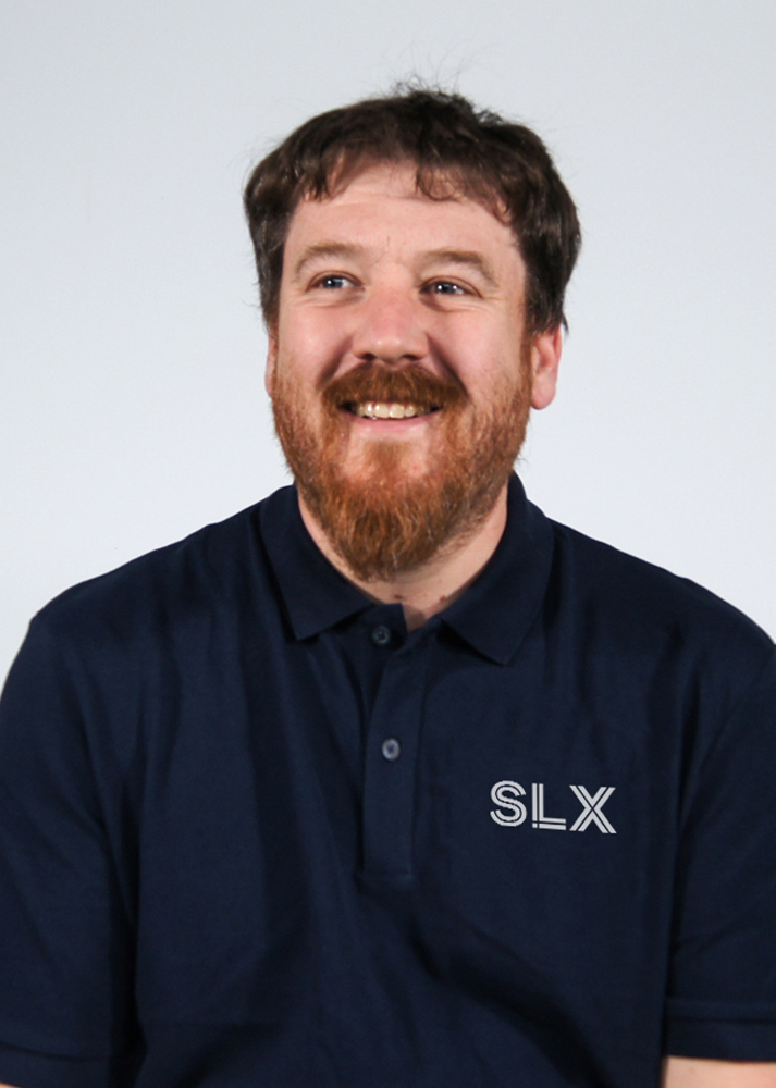 Kenn Harrison SLX Maintenance Coordinator smiling looking away from the camera on a white background